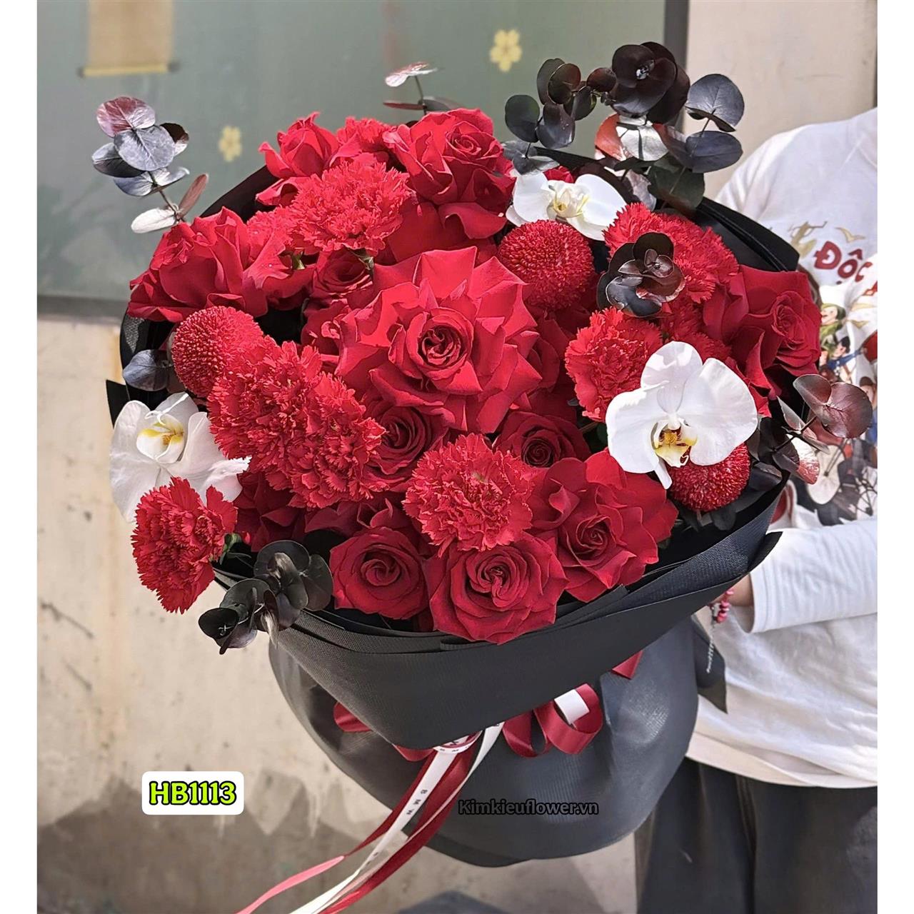 bó hoa tone đỏ được mix nhiều loại hoa, gói giấy đen tạo nên sự huyền bí cho bữa cầu hôn